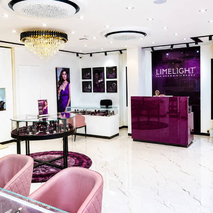 Luxury jewelry showroom interior with purple accents, glass display counters, chandelier lighting, and modern white decor.